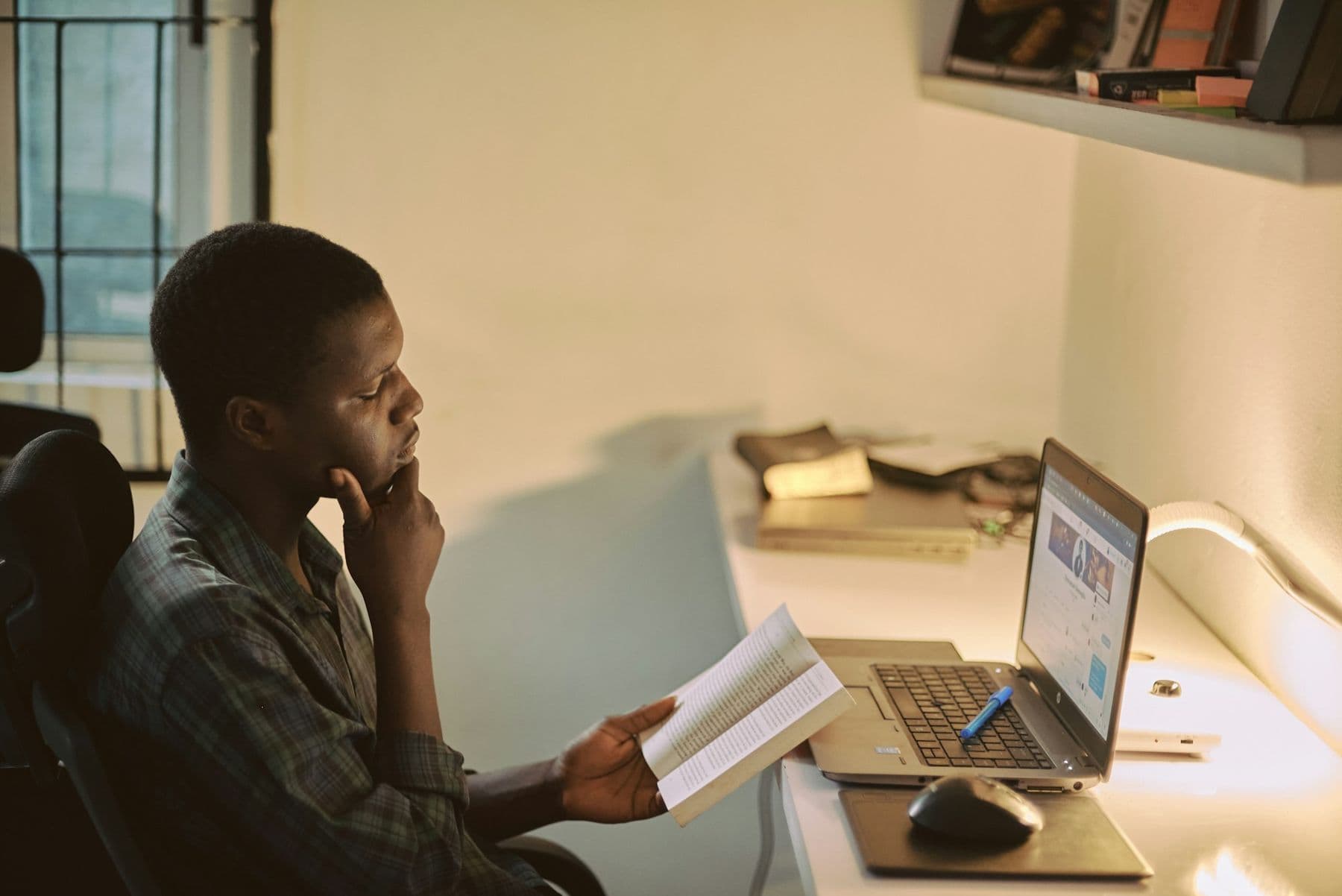 A lawyer reviewing a case file beside his laptop